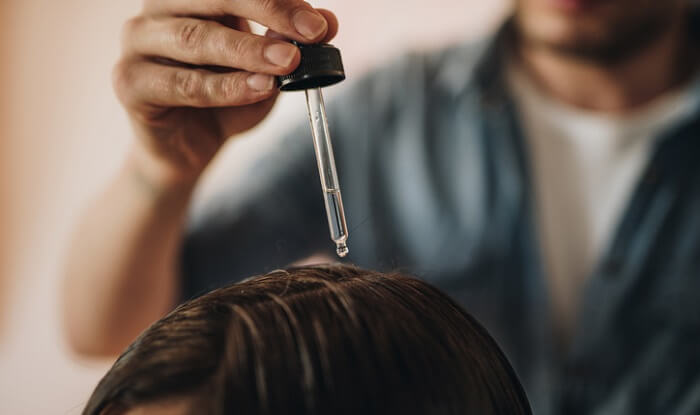 hair dressing applying essential oils to woman