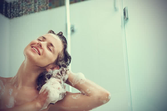 Smiling Woman In The Shower Washing Hair